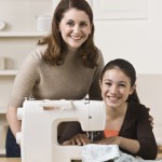 Mother and daughter sewing doll clothes together
