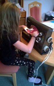 Ruth's granddaughter learning how to sew doll clothes